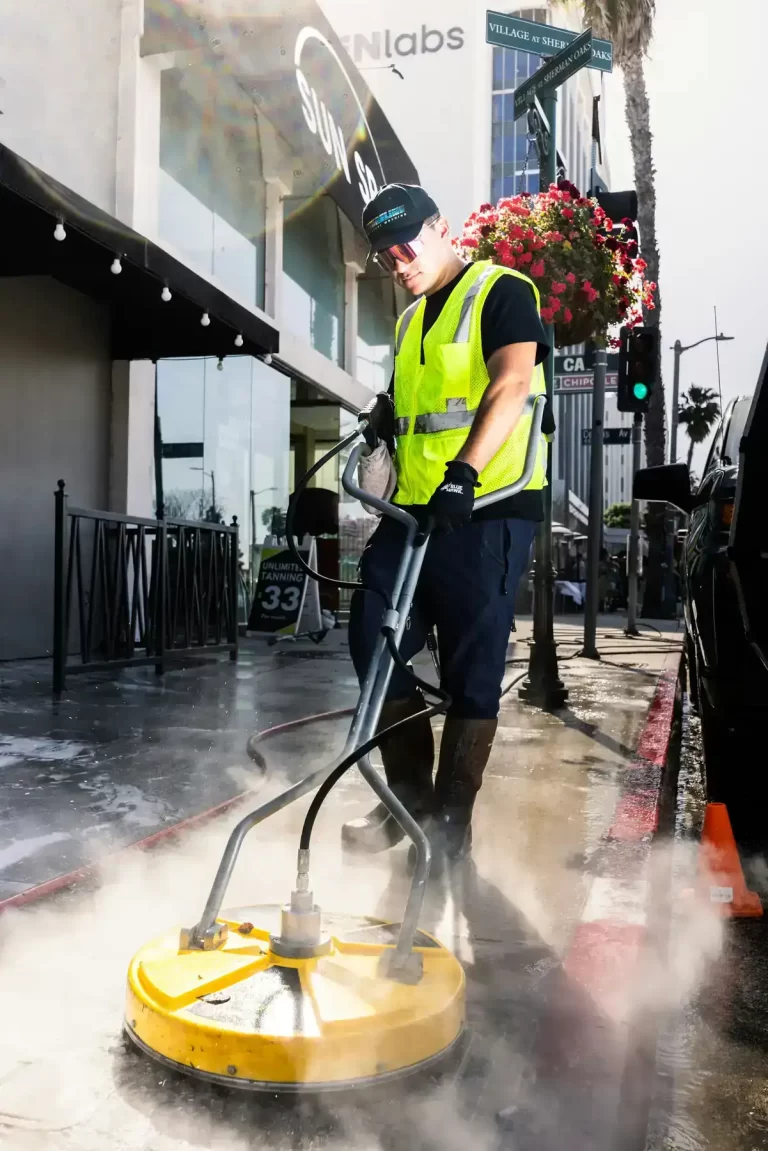 man pressure washing concrete sidewalk in downtown richmond va