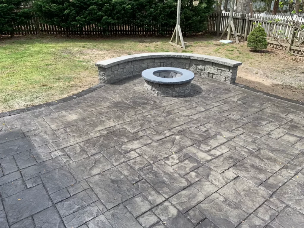 Patios & Concrete in Chesterfield & Richmond | Peachers stamped concrete patio with brick fireplace and seating wall in richmond virginia